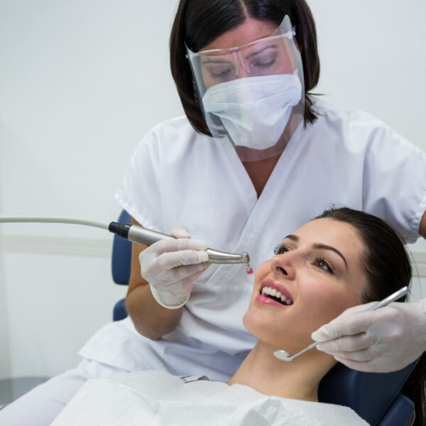 dentist-examining-female-patient-with-tools